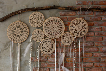  dream catchers made with their hands weigh on a brick brown wall
