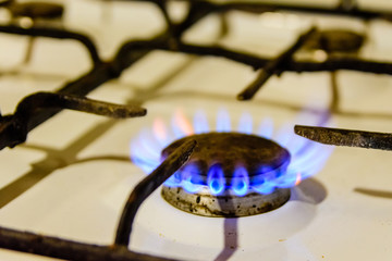Gas burner on the white kitchen stove