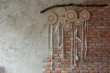  dream catchers made with their hands weigh on a brick brown wall