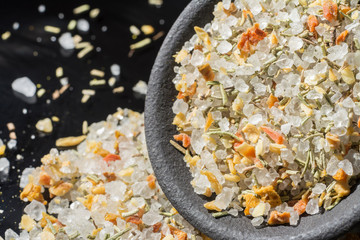 Macro collection, white sea salt mixed with italian herbs, rosemary and spices on black close up