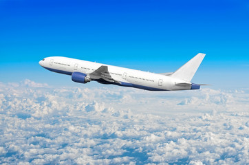Naklejka na ściany i meble Passenger airplane fly on a hight above overcast clouds and blue sky.