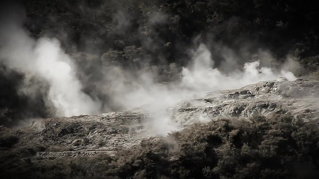 Slow motion. Geothermal area at Rotorua New Zealand. Hot springs, silica terraces, and steaming vents at Whakarewarewa Thermal Park - one of NZ’s top tourist attractions. Monochrome tinted footage.