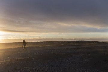 photographer walk on diamond black sand beach Iceland in morning with dramatic sky in backgrounds.