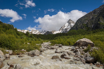 Movement of clouds and water flows in a stormy river in the Caucasus mountains in summer