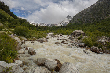 Movement of clouds and water flows in a stormy river in the Caucasus mountains in summer