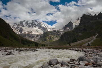 Movement of clouds and water flows in a stormy river in the Caucasus mountains in summer