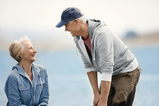 Smiling senior couple standing on a beach together.