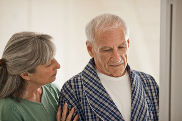 Senior woman comforting her unwell husband.