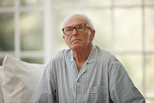 Concerned senior man wearing pajamas inside a rest home.