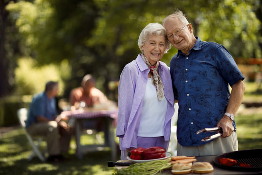 Smiling senior couple at a barbecue in the park.