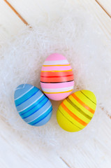 Beautiful bright postcard (background) for a light Easter holiday - three multicolored easter easter eggs