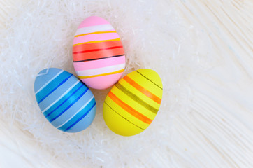 Beautiful bright postcard (background) for a light Easter holiday - three multicolored easter easter eggs