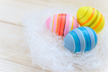 Beautiful bright postcard (background) for a light Easter holiday - three multicolored easter easter eggs