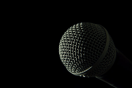 Isolated microphone head against pitch black background