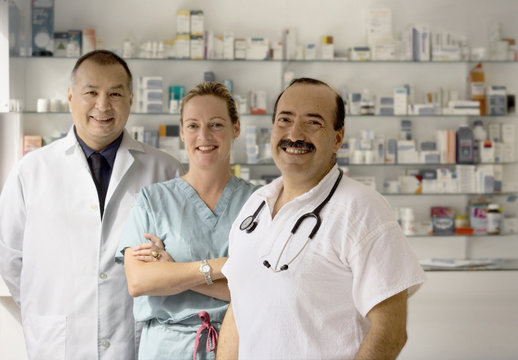 A team of three doctors smile at the camera.