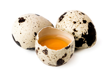 Two quail eggs and broken on a white, isolated.