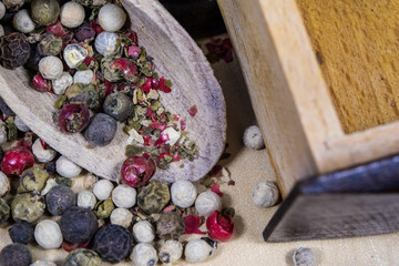 A grain of pepper on a kitchen table. Ground pepper in a kitchen mill.