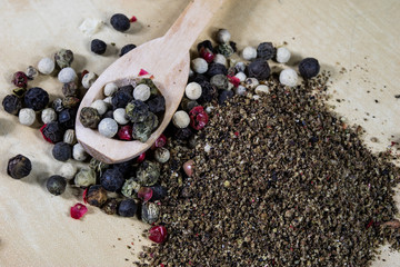 A grain of pepper on a kitchen table. Ground pepper in a kitchen mill.