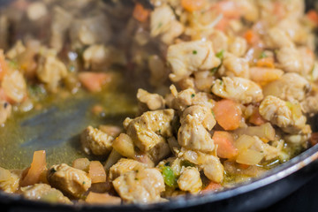 Cooking burrito in a pan with chicken, pepper, tomato for fajitas typical Latin America food