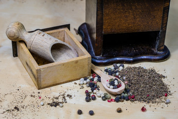 A grain of pepper on a kitchen table. Ground pepper in a kitchen mill.