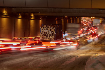 Tunnel at night. From the fast-moving cars remains a beautiful trail. Only the truck with the timber stopped at a steady pace.