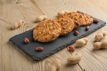 Fototapeta premium Cookies with peanuts on a wooden texture with nuts.