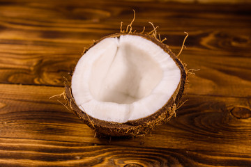 Ripe halved coconut on a wooden table
