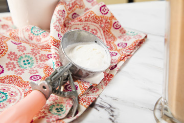 Close up of an ice cream scoop with melting vanilla ice cream