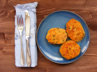 Rissoles of ham, cheese  and potatoes on blue plate on rustic background with blue napkin and cover
