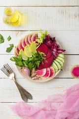 Fresh salad with beets, watermelon radish, cucumber, parsley, lime, garlic, olive oil, mix salads. Healthy concept. White background. Flat lay. 