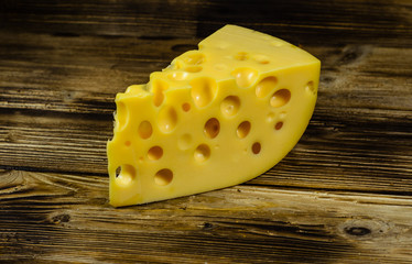 Piece of cheese on wooden table