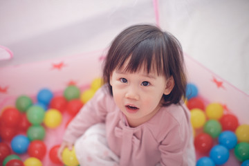Fototapeta na wymiar baby girl play tent and ocean ball at home