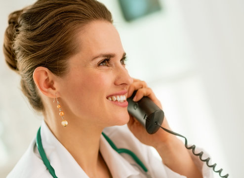 smiling medical doctor woman talking phone