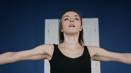 In gym young woman trains the arm muscles with two pink dumbbells. exercises. Fitness muscled woman in black sport clothing workout in gym