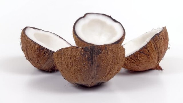 Four ripe tropical coconut halves with yummy white pulp rotating on white isolated background. Healthy fresh tropical fruits. Loopable seamless cocos rotating