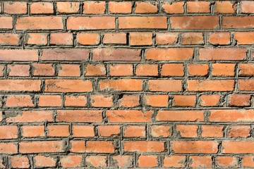 A wall of smooth dark orange bricks. Blank texture background of brickwork.