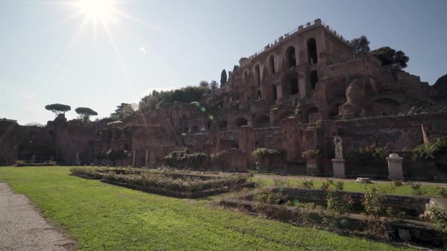 Beautiful view of Palatine Hill from the Roman Forum with a lens flare and a pan right