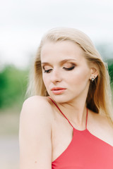 young girl with white hair on a green background in a red dress