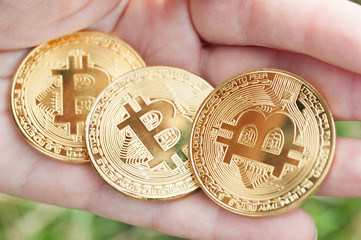 The female hands hold the three coin on the dark background