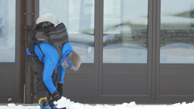 Bielmonte, Italy-February 6, 2018: Middle-aged man controls and system skis in the snow. Adult prepares for skiing in Alpine Scenic