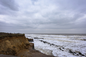 UK, HAPPISBURGH - 18 MAR 2018: Coastal erosion taking place during a winter storm. Many homes have recently been lost in this community due to the sea eating away the coastline.