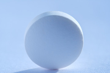 Pill tablet medicine lying isolated on white, extreme close-up macro.