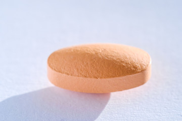 Pink Pill tablet medicine lying isolated on white, extreme close-up macro.