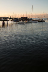 Fototapeta premium Sunset with Sailboats anchored in the pier
