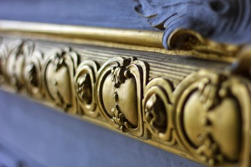 Golden element of wood molding Closeup of ornamental wooden molding with painted golden design