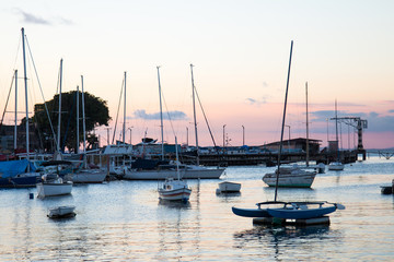 Fototapeta premium Sunset with Sailboats anchored in the pier