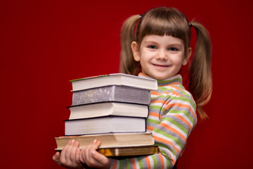 Little girl hold many books isolated on red. Concept of knowledge or school. Book lover.