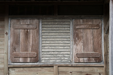 Obraz na płótnie Canvas window with closed shutters - wooden building exterior with closed shutter