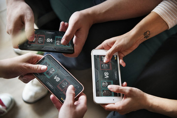 Group of diverse friends playing game on mobile phone