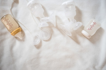 Breast pump equipment and bottle of breast milk for new born baby with white blanket background for text space